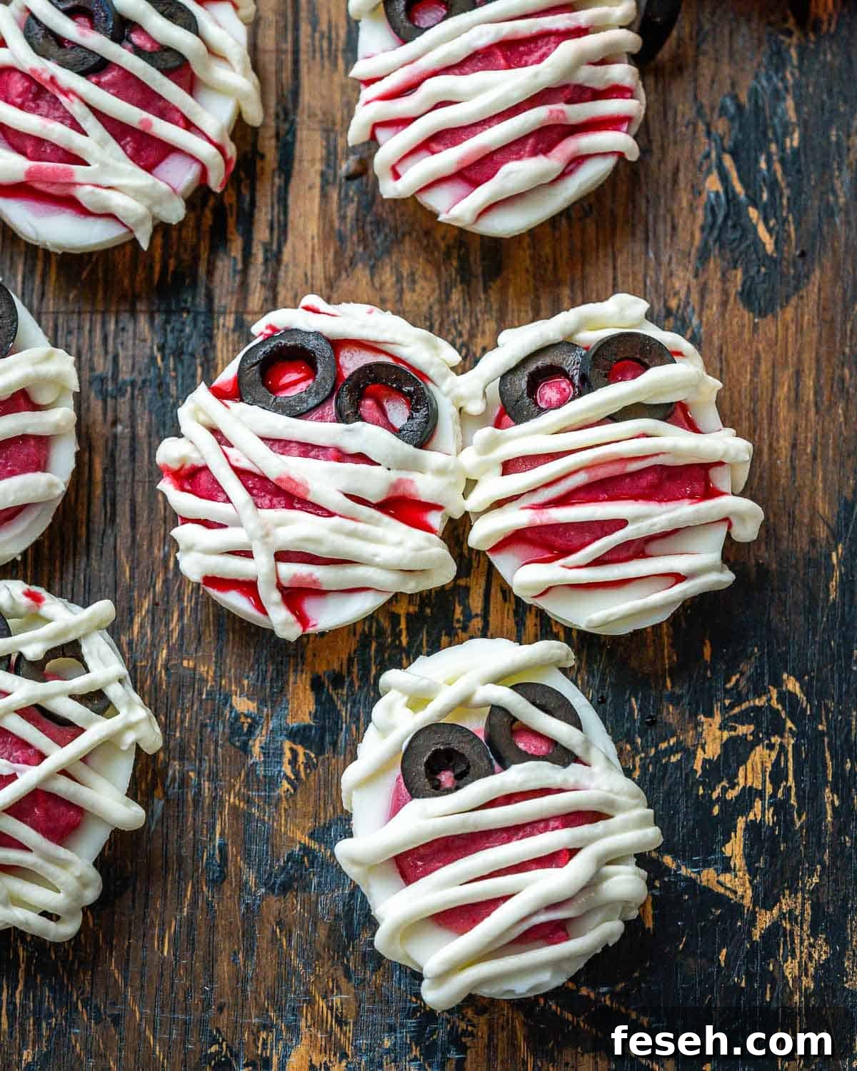 Spooky halloween deviled eggs, made to look like mummies with beetroot filling and cream cheese bandages