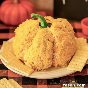pumpkin cheese ball on a plate surrounded by crackers.
