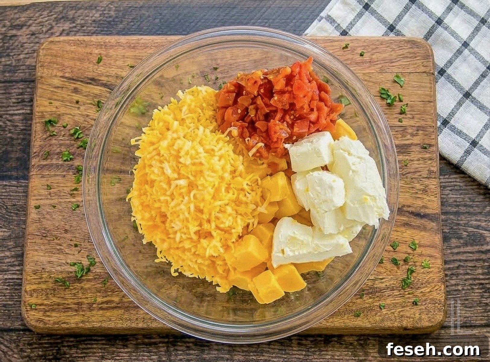velveeta, cream cheese, rotel, and shredded colby jack cheese in a bowl.