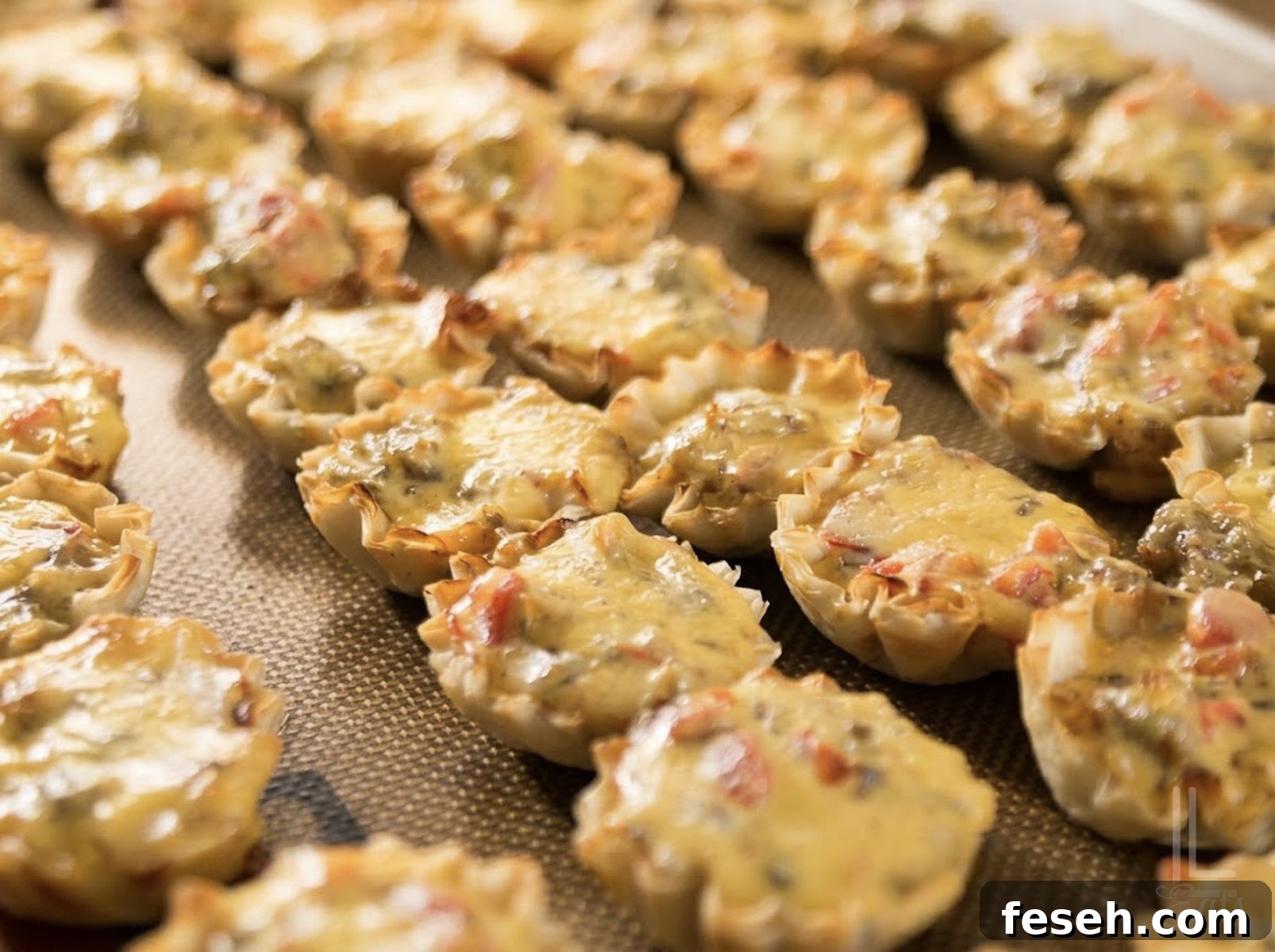 cooked sausage rotel cups on a baking sheet.
