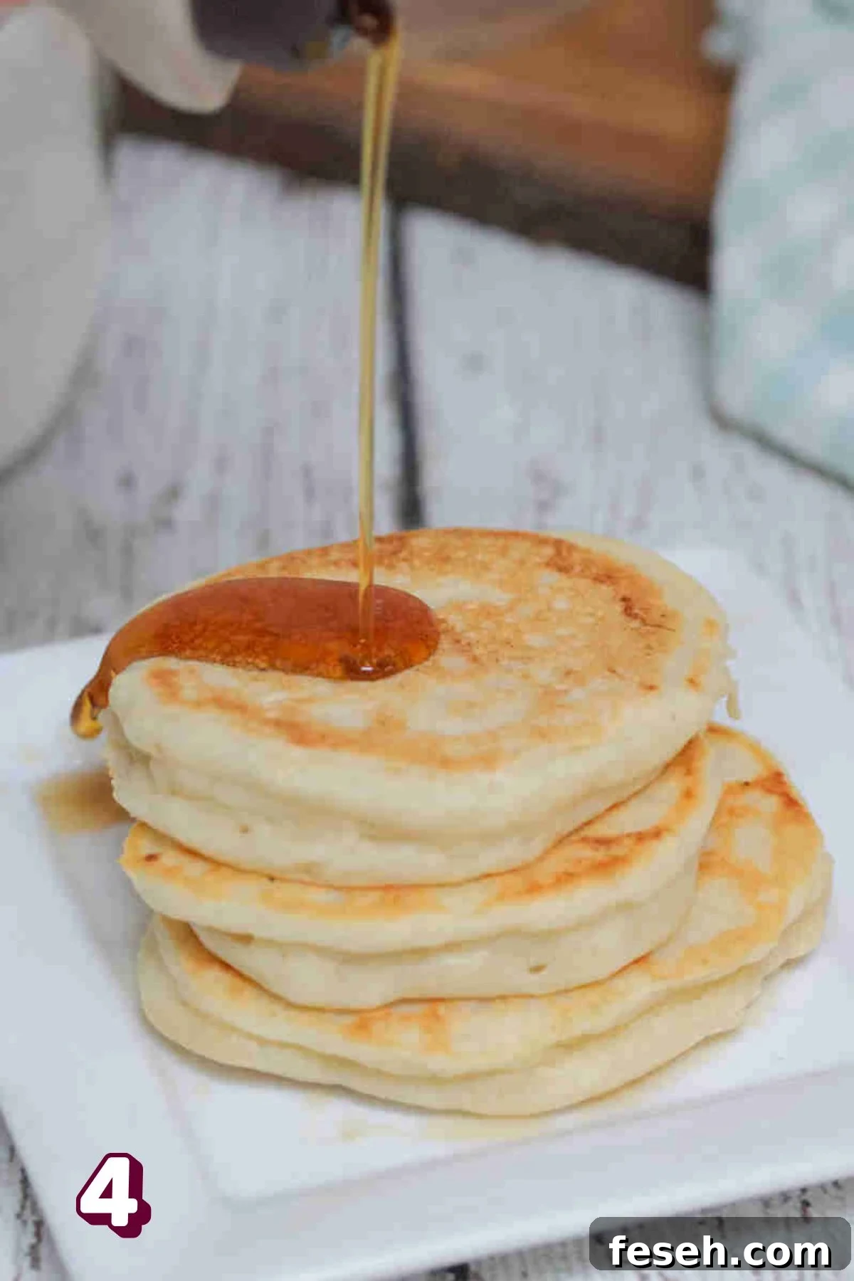 A stack of pancakes with maple syrup on a plate.