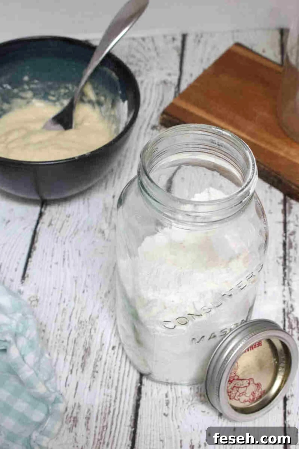 Homemade protein pancake mix inside a jar, with a bowl of pancake batter at the background.
