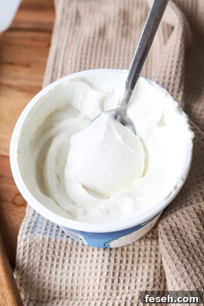 Blended cottage cheese in a container with a spoon.