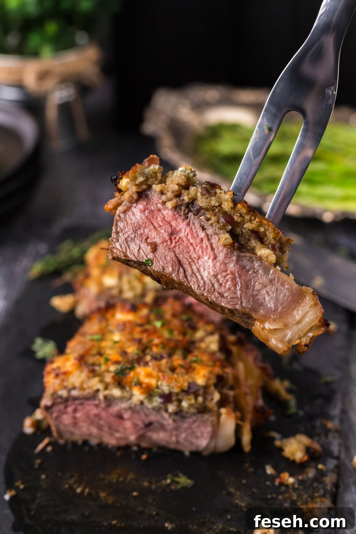 Meat fork lifting up a piece of Blue Cheese Crusted Steak