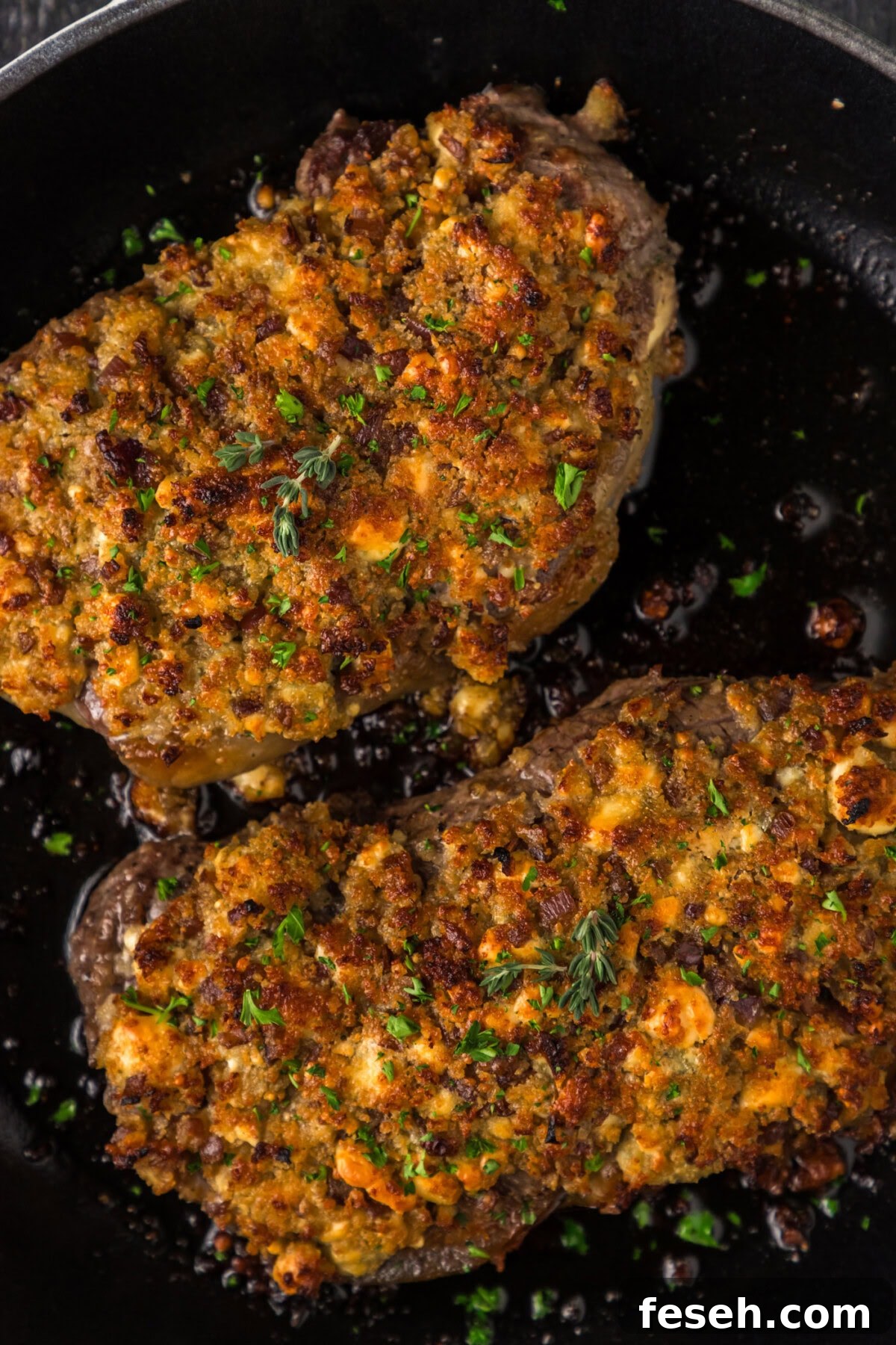 Close up photo of two Blue Cheese Crusted Steaks in a skillet