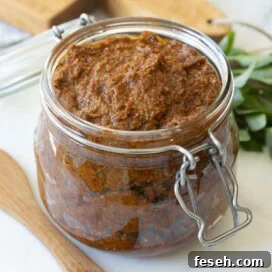 Glass jar of pesto rosso, red pesto, ready to enjoy.
