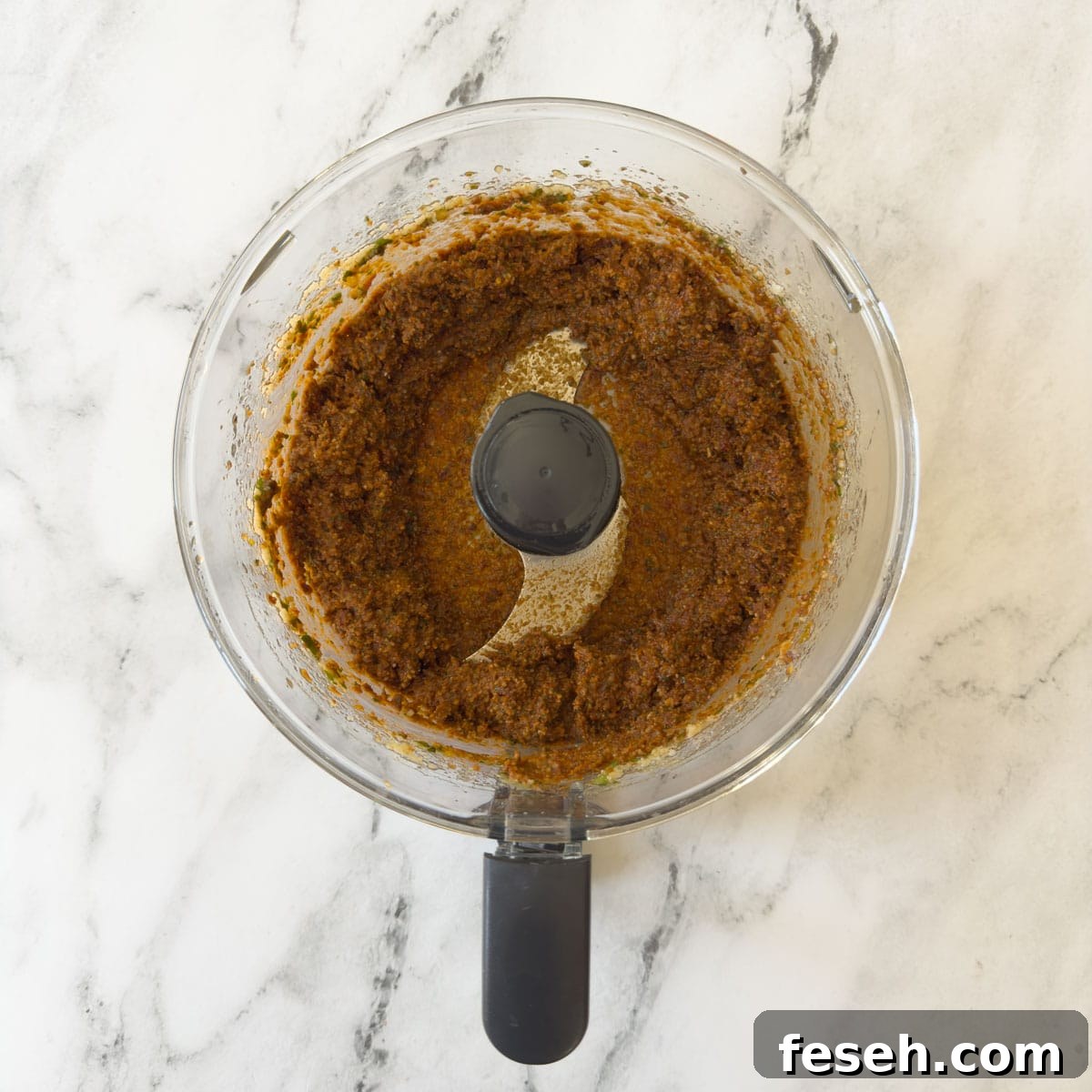Pesto rosso almost smooth in a food processor workbowl.
