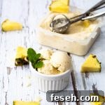 Bowl of pina colada nice cream and scoop plus pineapple pieces