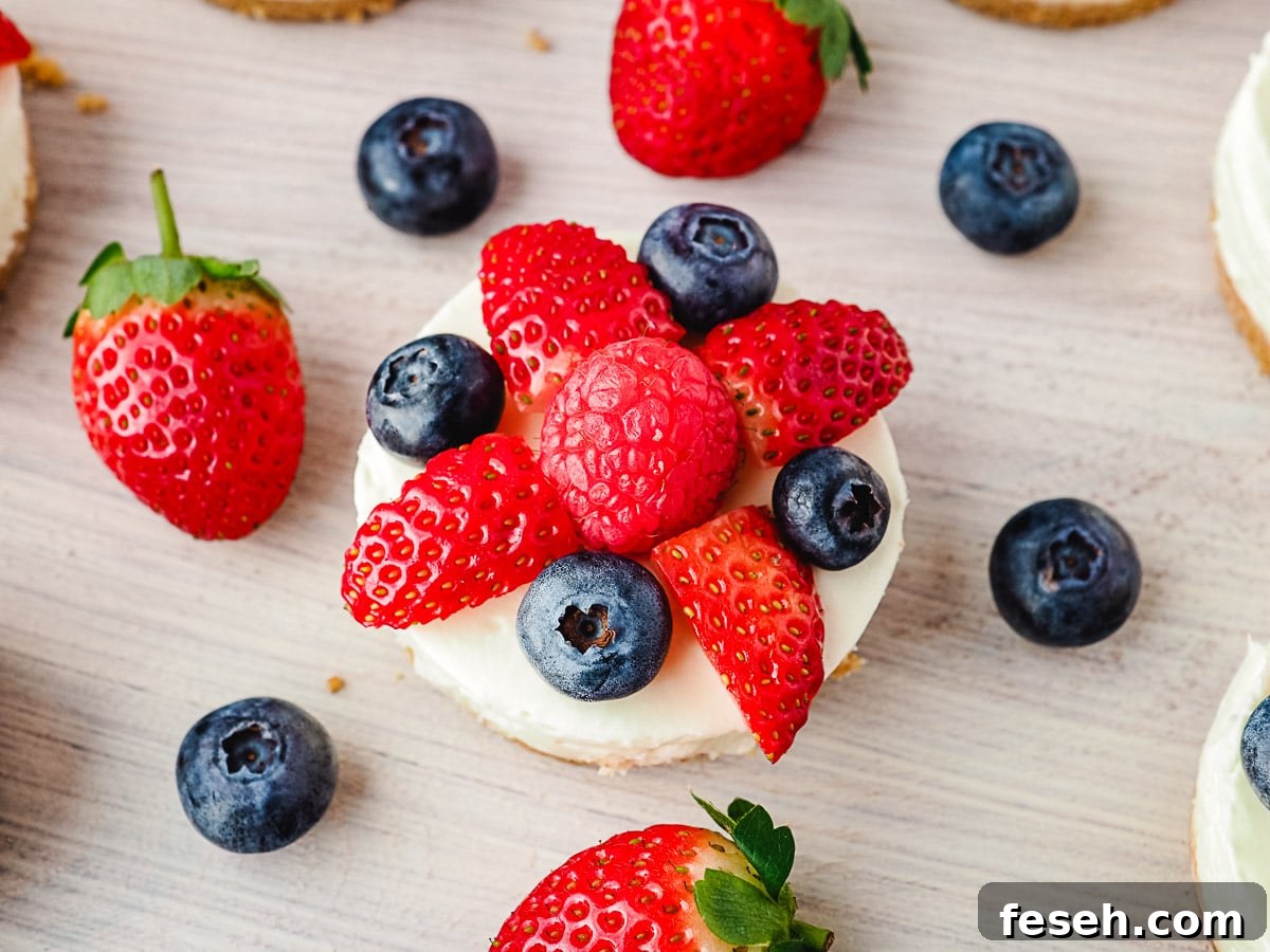 Cheesecakes on a platter with fresh fruit.