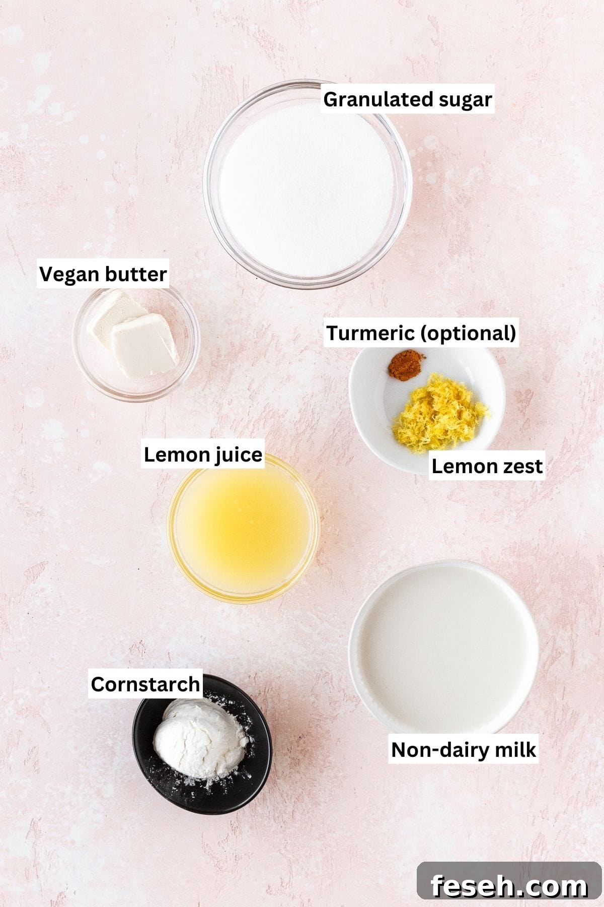 Ingredients needed for making vegan lemon curd measured out into bowls on a pink table with text overlay.