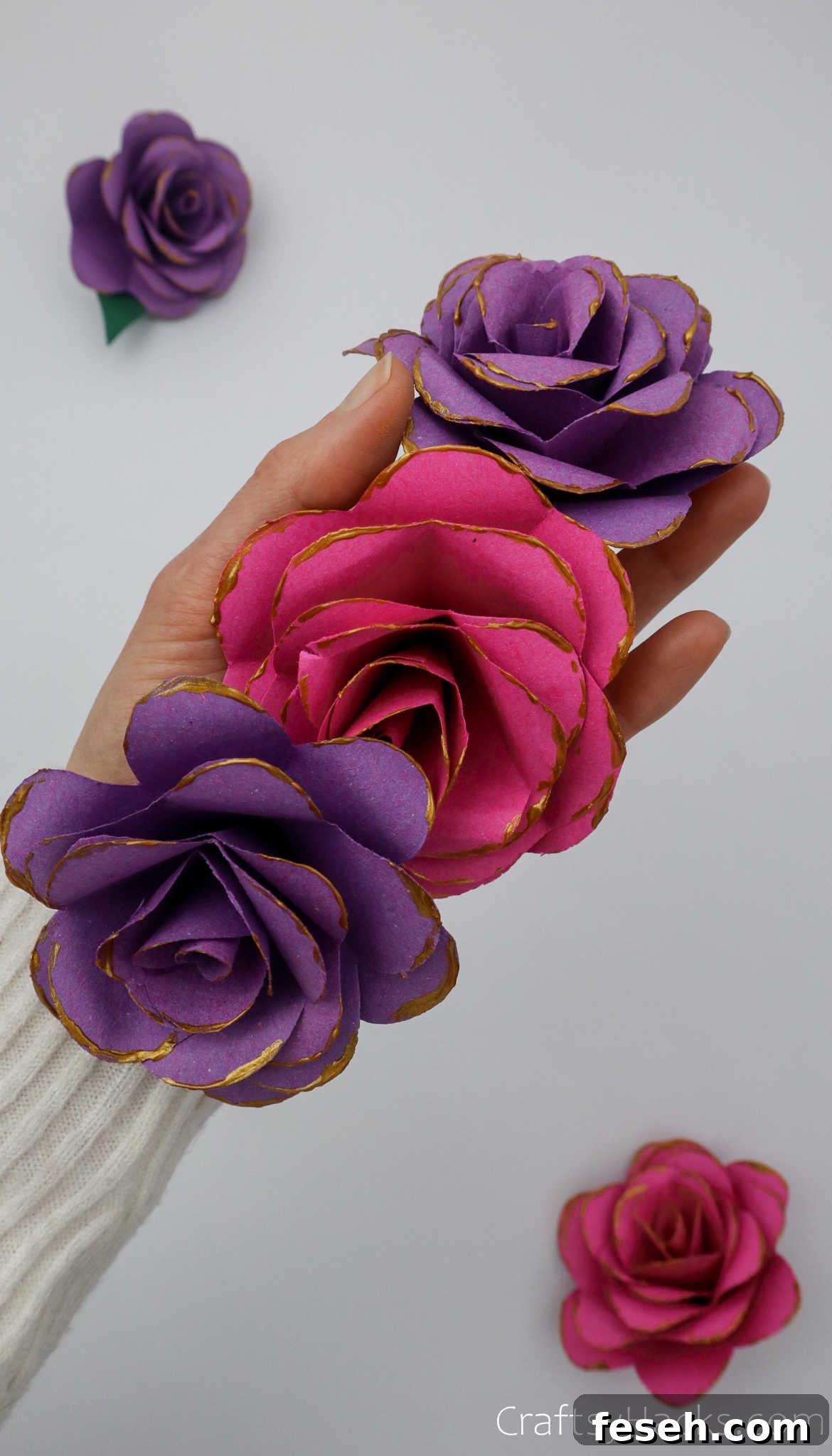 holding three paper flowers