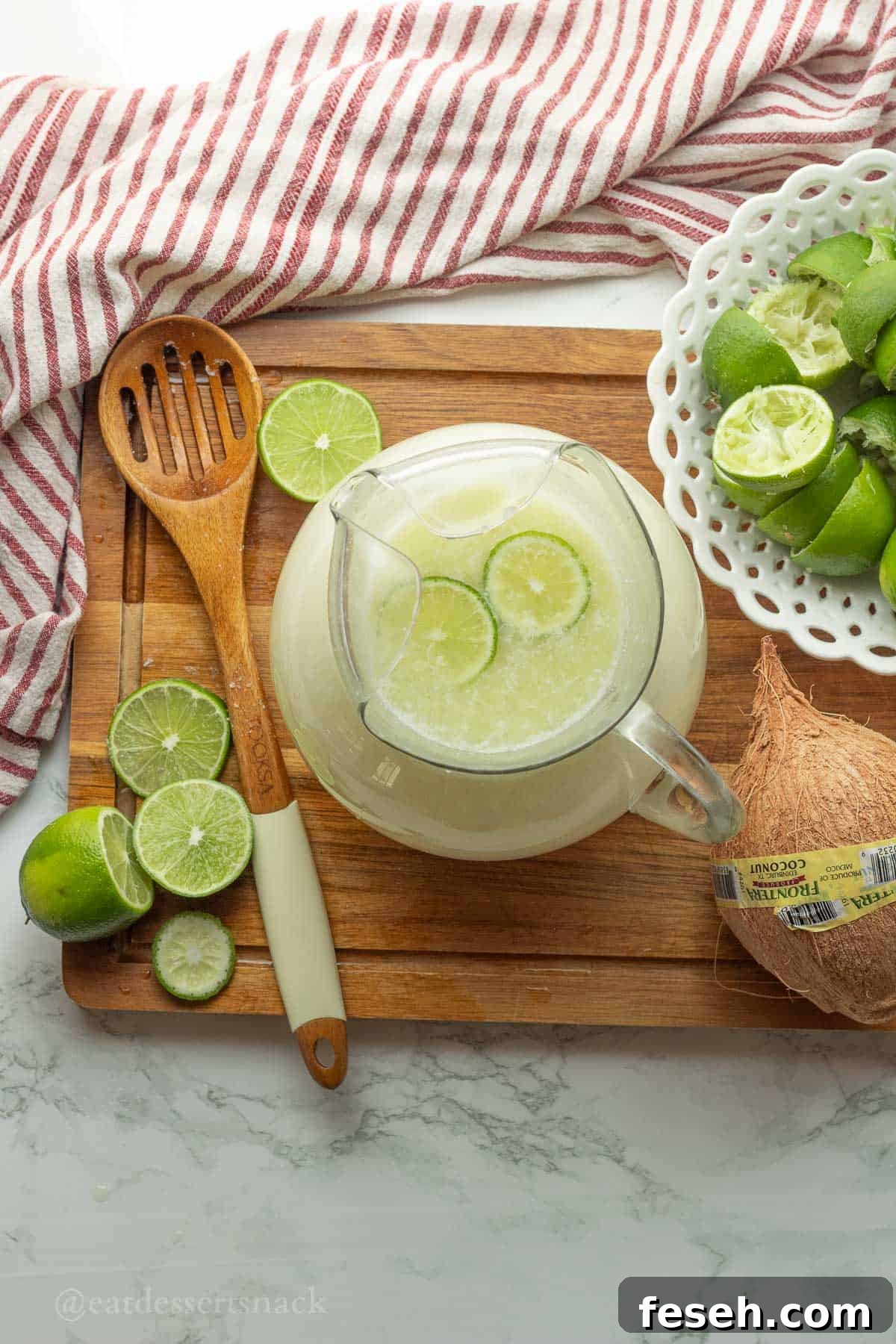 Pitcher of lime drink with lime slices.