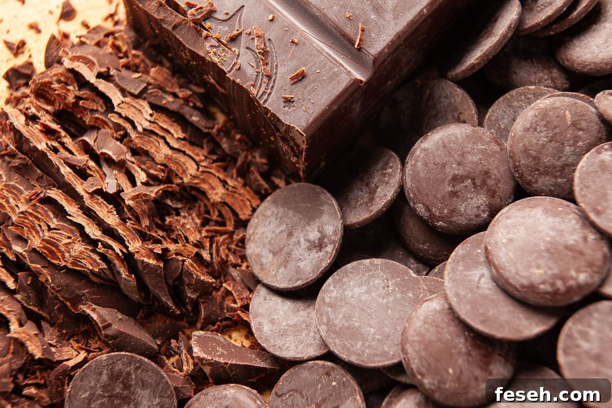 Chopping chocolate bars and chocolate coins to make chocolate dessert.