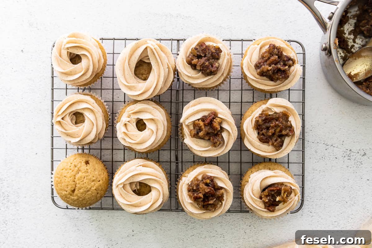 showing how to frost pecan pie cupcakes with a frosting ring around the top of each cupcake and pecan pie filling in the center