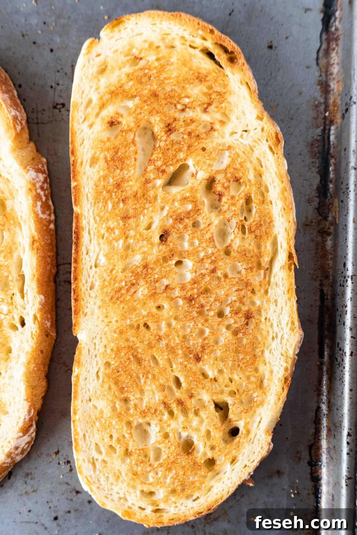 toasted sourdough bread slice on baking sheet.