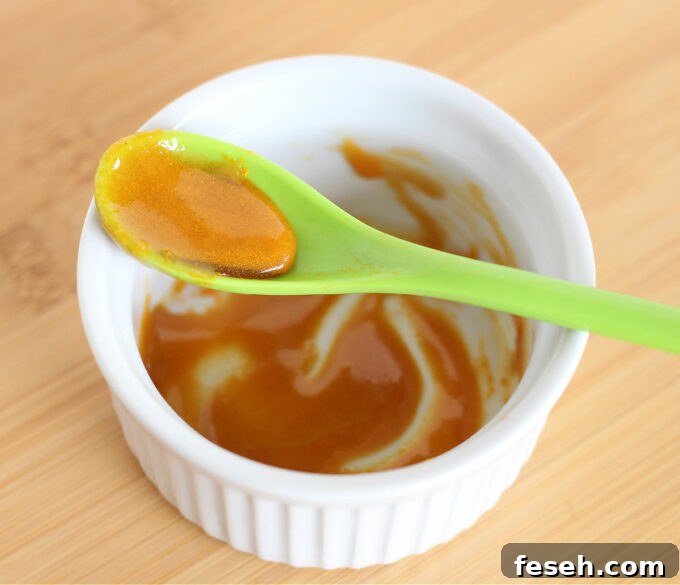 Turmeric and honey mixed together in a white bowl.