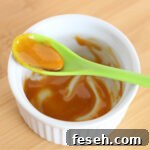 Turmeric and honey mixed together in a white bowl.