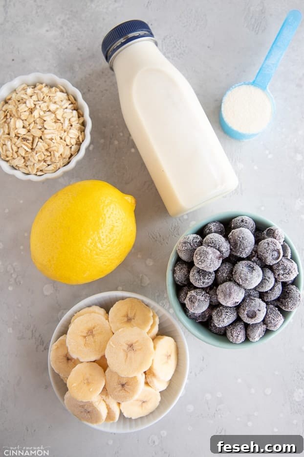 Ingredients for lemon blueberry smoothie: frozen banana and blueberries, oats, a lemon, some milk and protein powder
