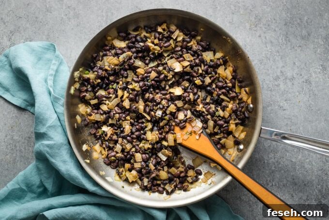 Cooked black beans in a skillet.