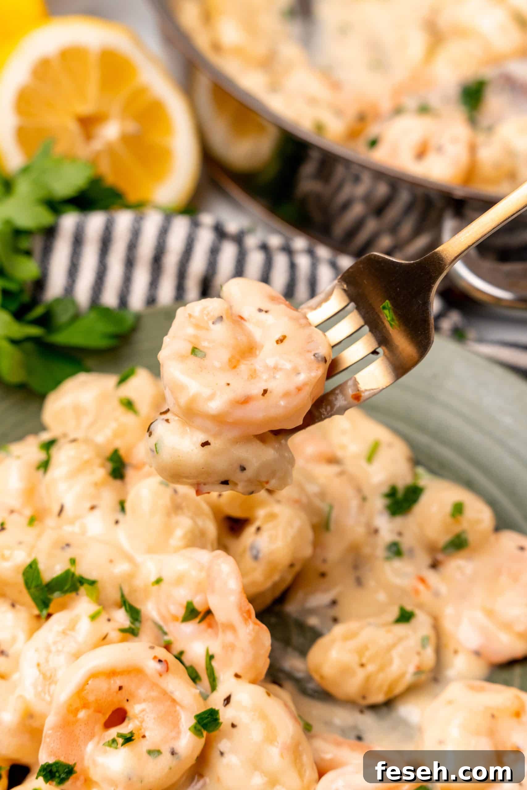 a golden fork holding up a scoop of creamy gnocchi shrimp scampi