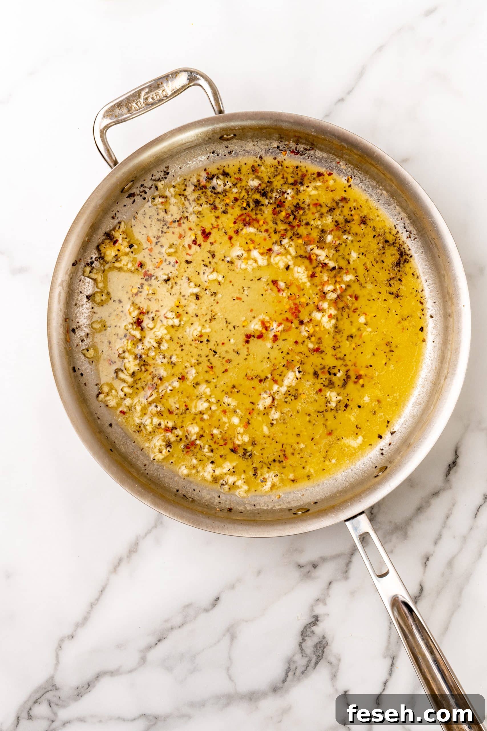 seasoned garlic butter sauce in a large silver skillet