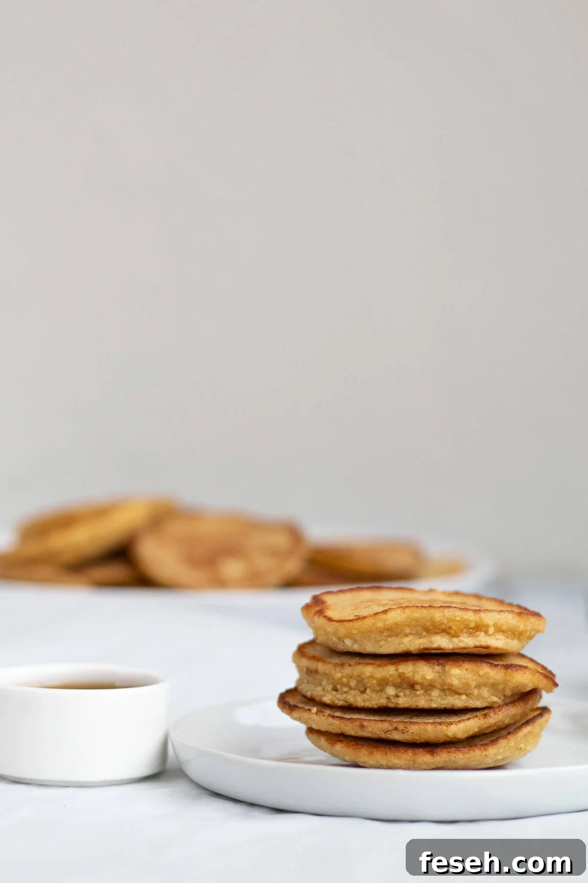 pancakes with syrup in a container next to them.