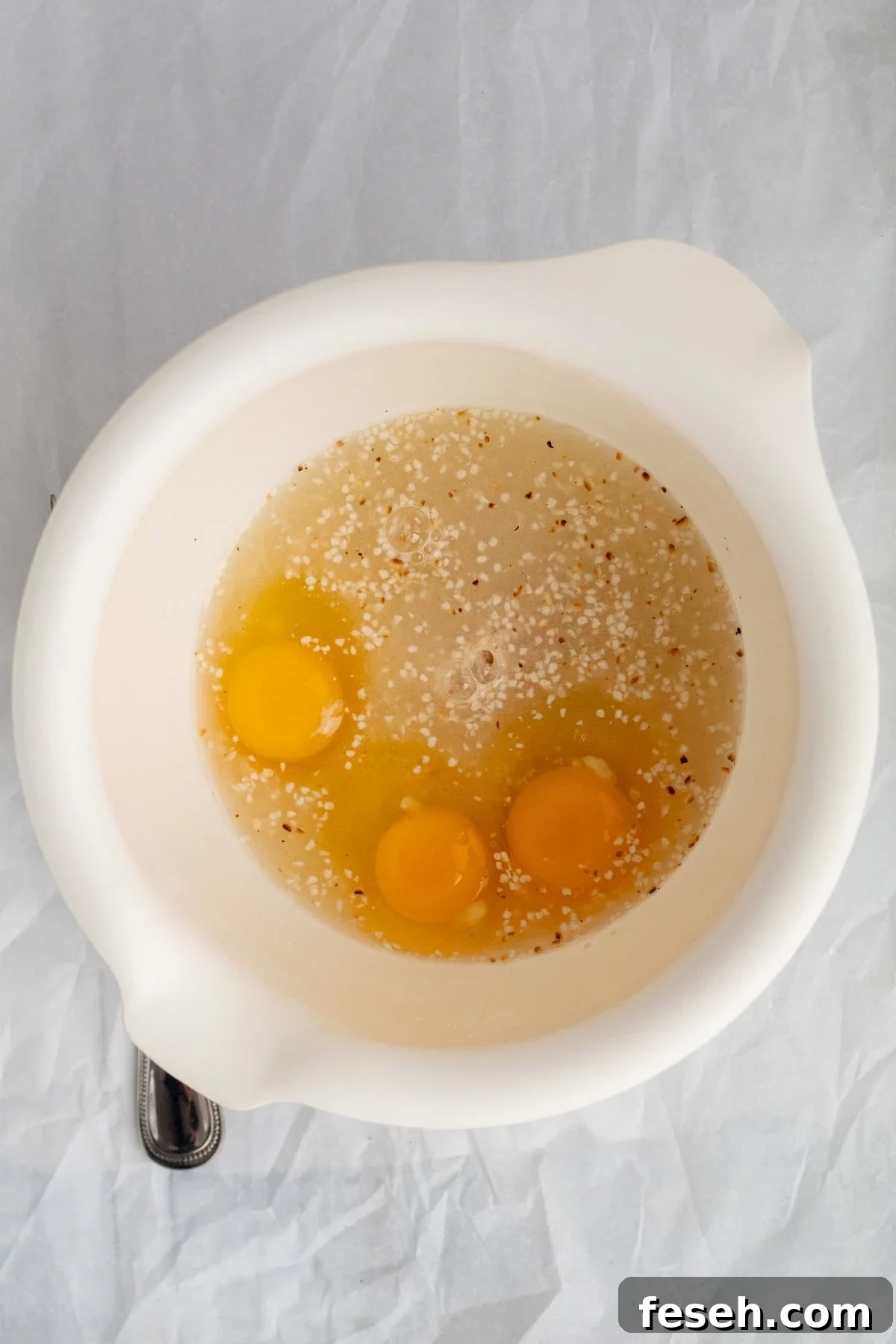 eggs and matzo meal in a white mixing bowl