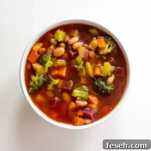 Bowl of detox vegetable soup on white background