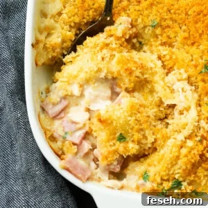 a photo of a chicken cordon bleu casserole with a serving being removed