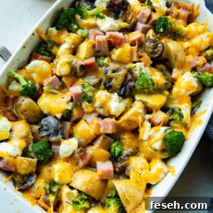 a photo of large white baking dish filled with hearty broccoli potato ham casserole