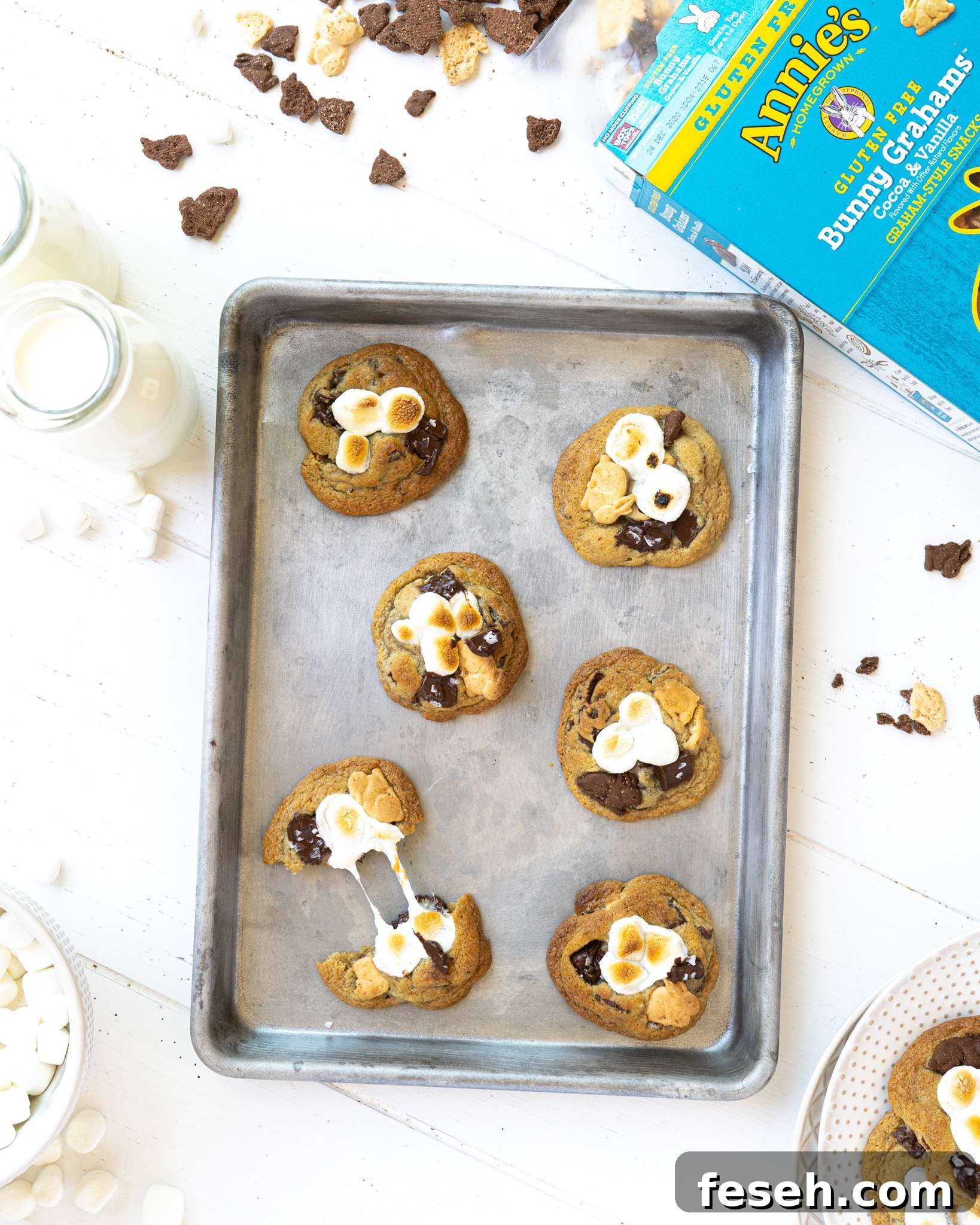 A gluten free s'mores cookie being pulled apart on a small baking sheet.
