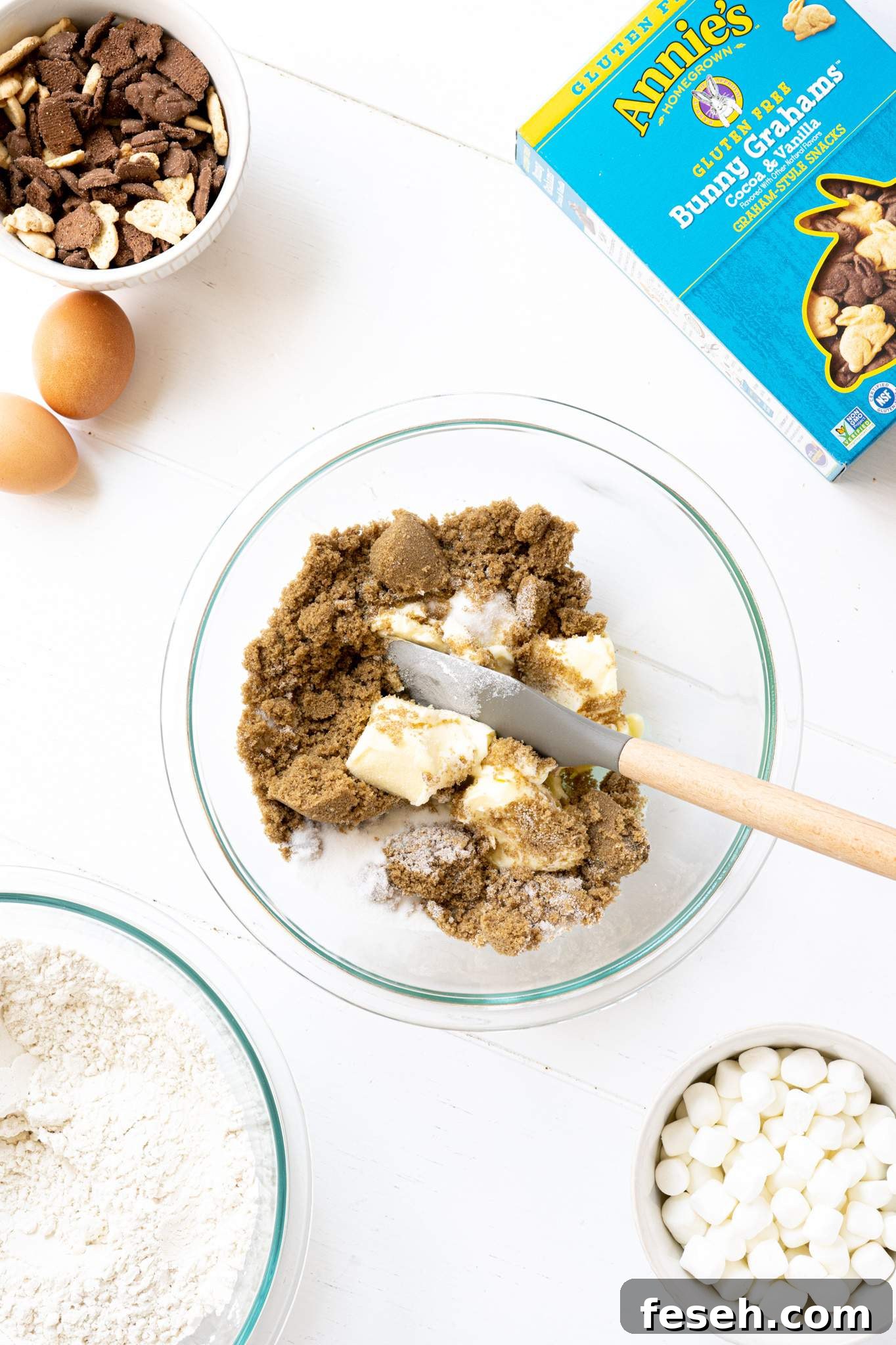 Butter and sugar in a mixing bowl with a spatula.