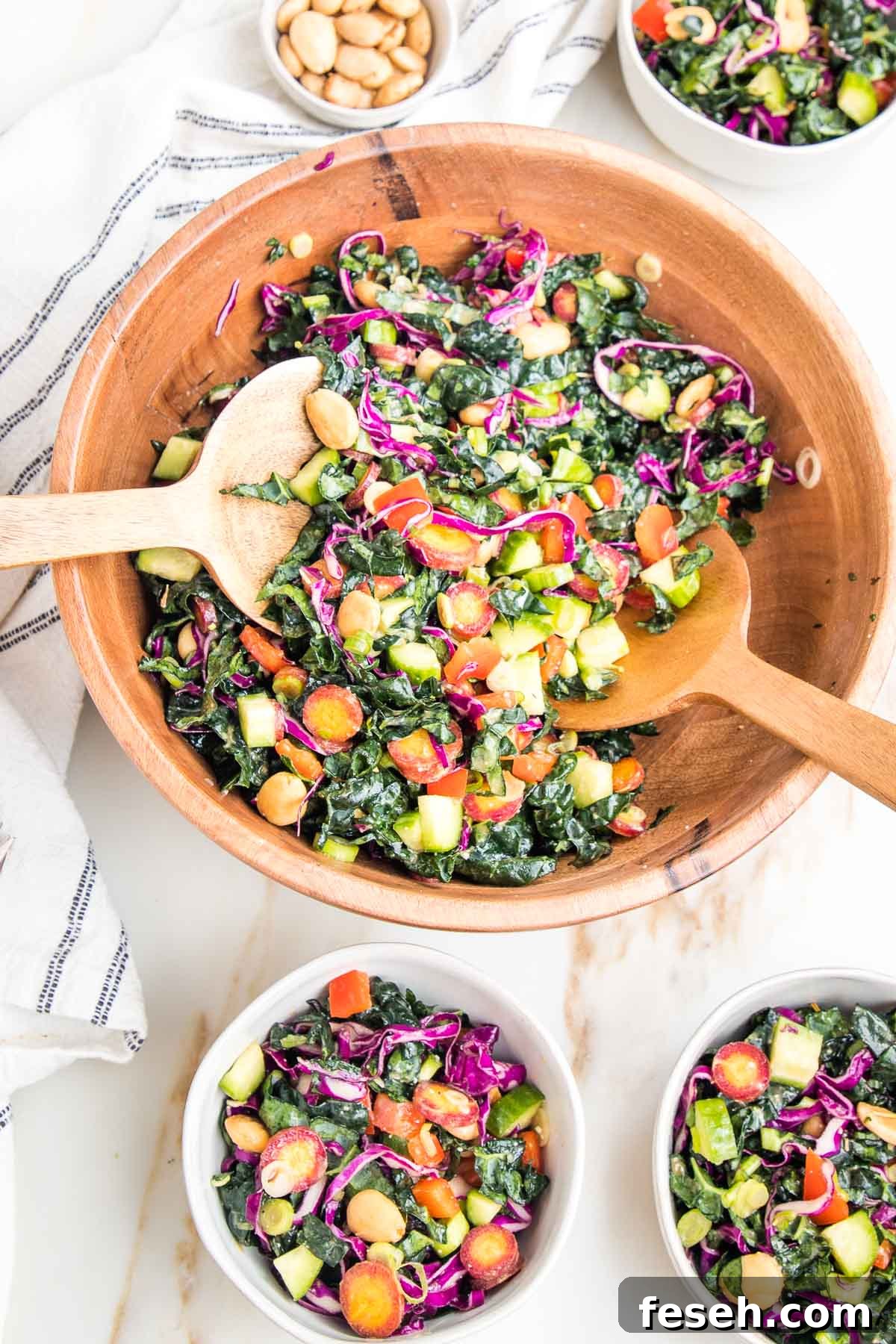 Colorful chopped kale salad in a wooden bowl. 3 small salad bowls filled with same salad.