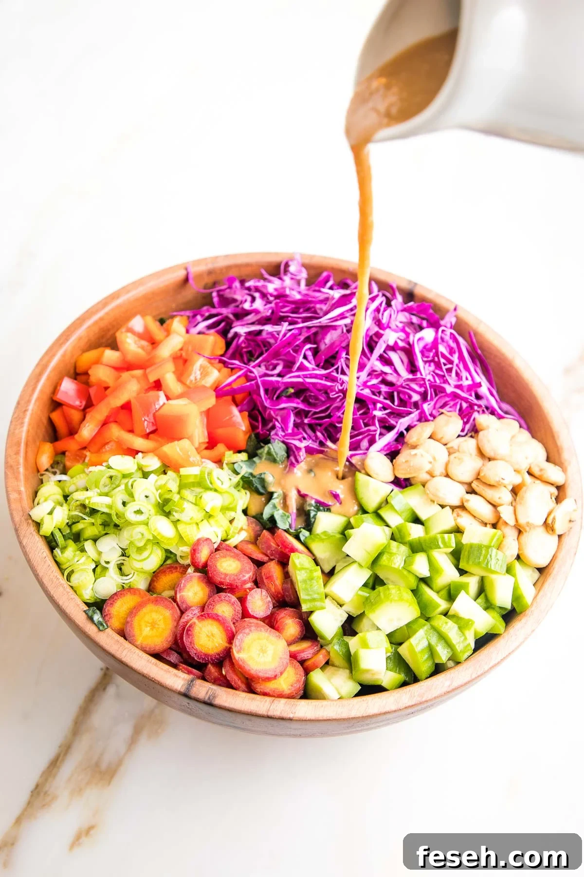 Dressing pour over colorful sections of chopped veggies.