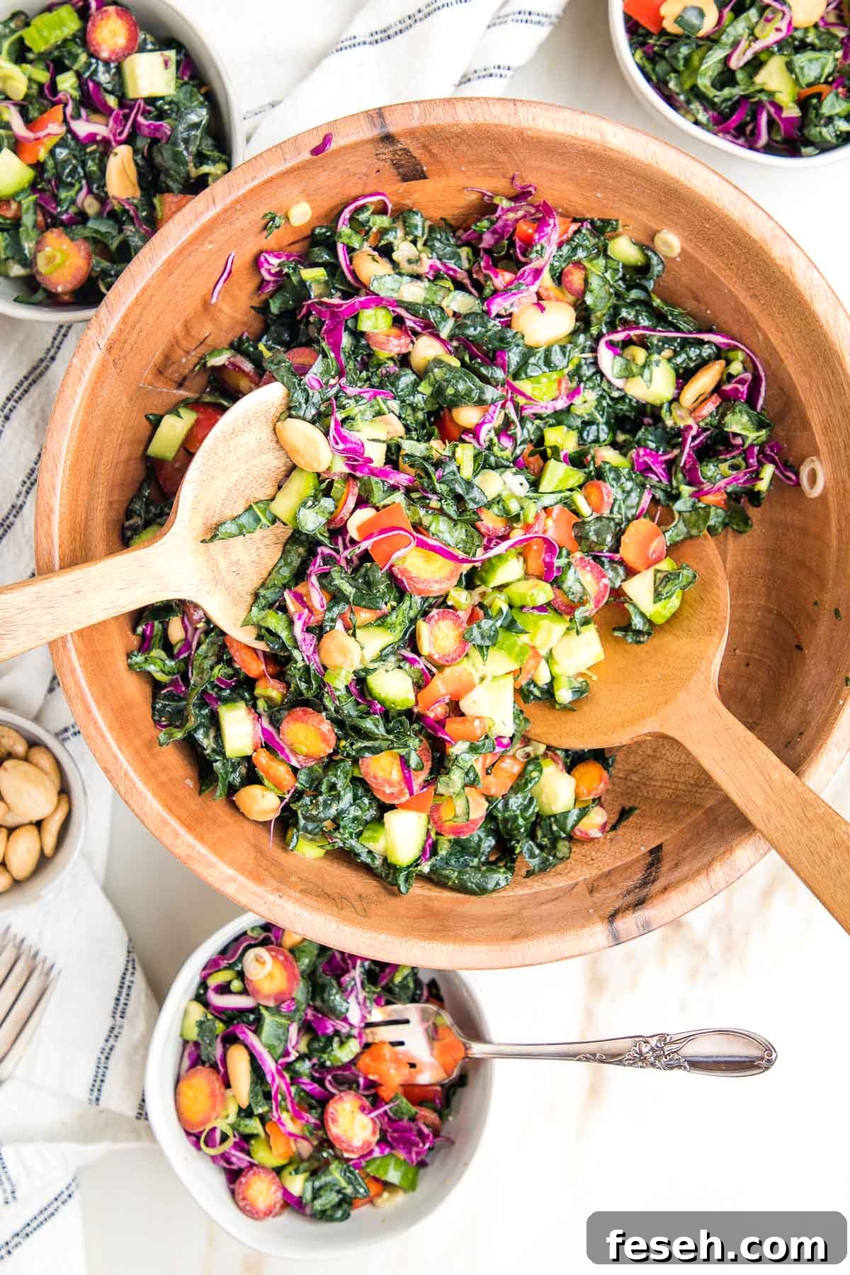 Colorful chopped tuscan kale salad with miso dressing in a wooden bowl.
