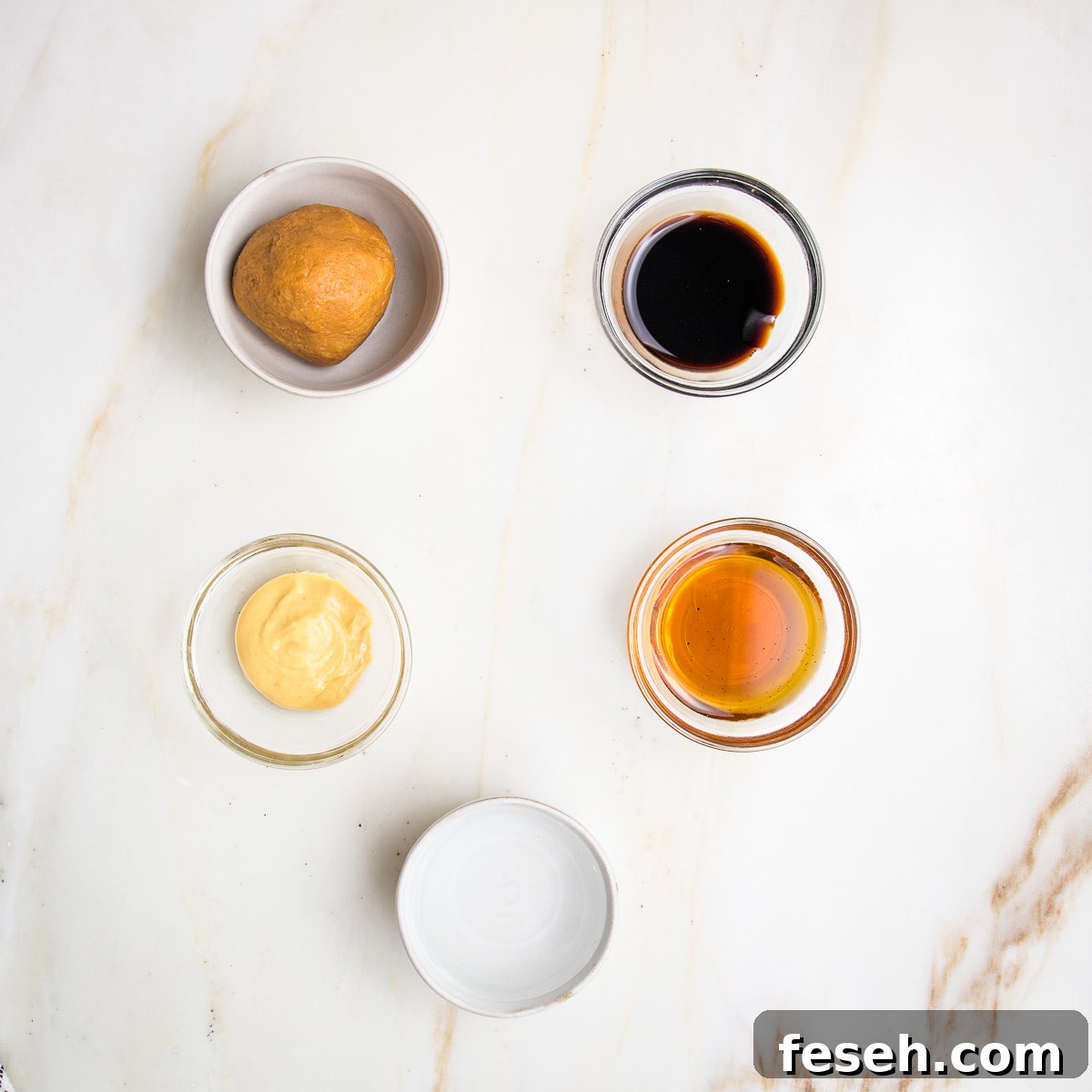 small bowls filled with light miso, balsamic vinegar, dijon mustard, maple syrup and water.