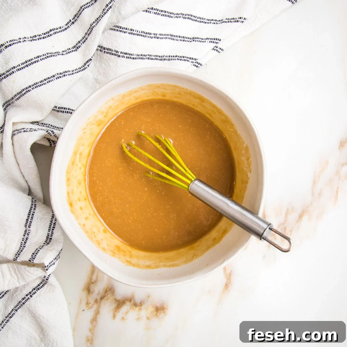Miso dressing in a small bowl with a whisk.