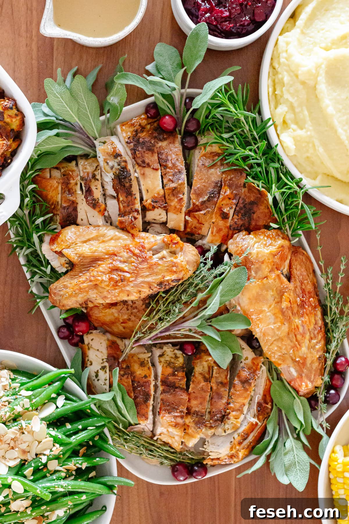 Overhead of a Thanksgiving turkey dinner set out on a wood table.