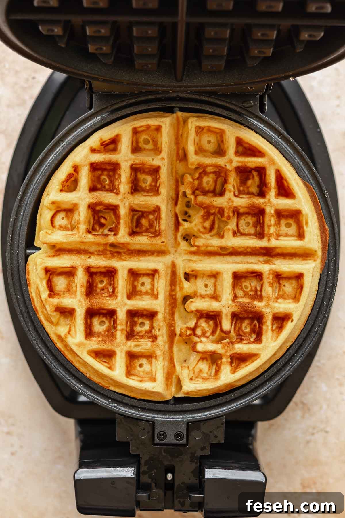 A cooked waffle in the waffle iron.