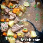 overhead shot of cooked Guinness beef stew in a black slow cooker
