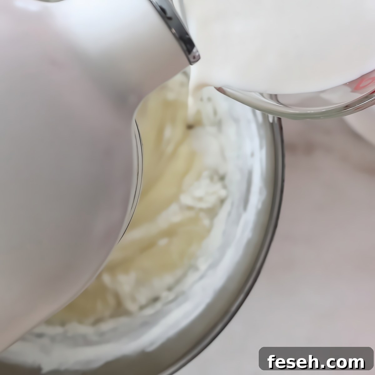 pouring milk into white stand mixer.