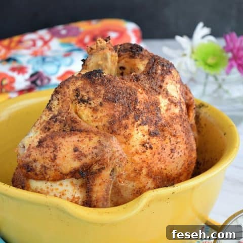 a crispy roasted chicken in a yellow roasting container