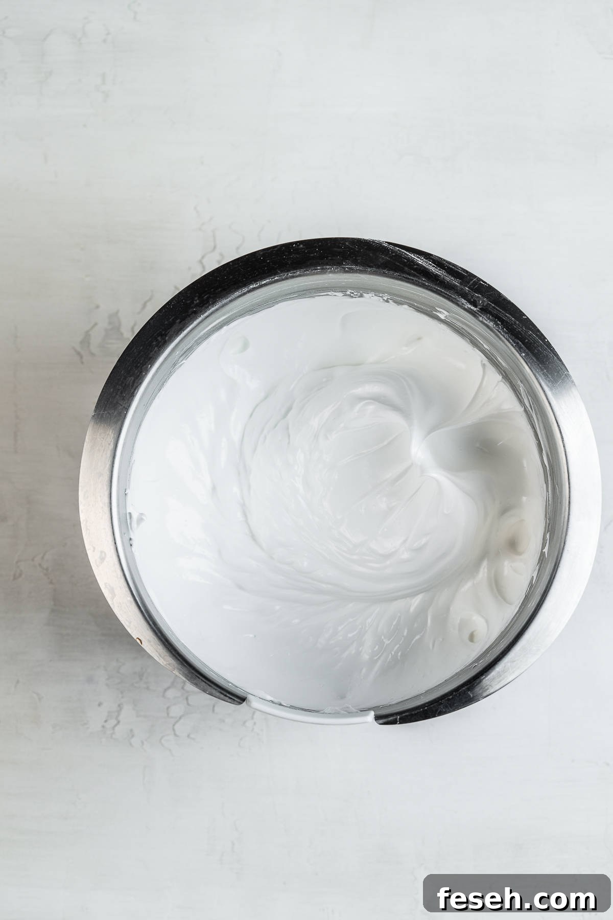 Whisked egg whites in a bowl.