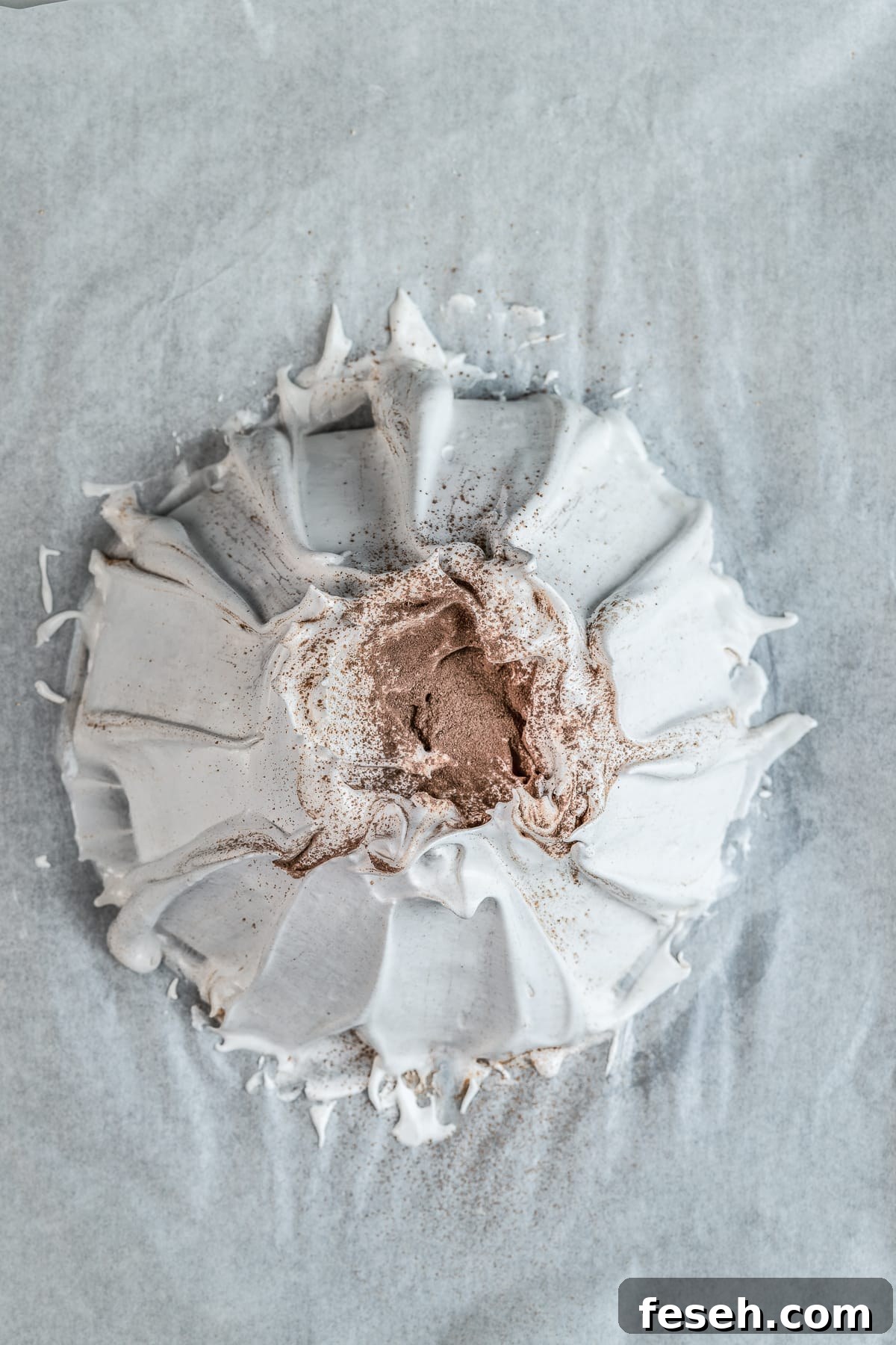 Unbaked meringue shell on parchment paper.