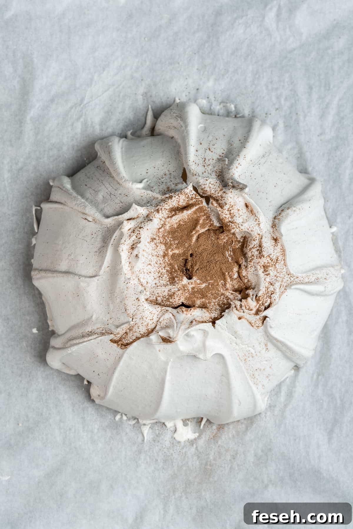 Baked meringue shell on parchment paper.