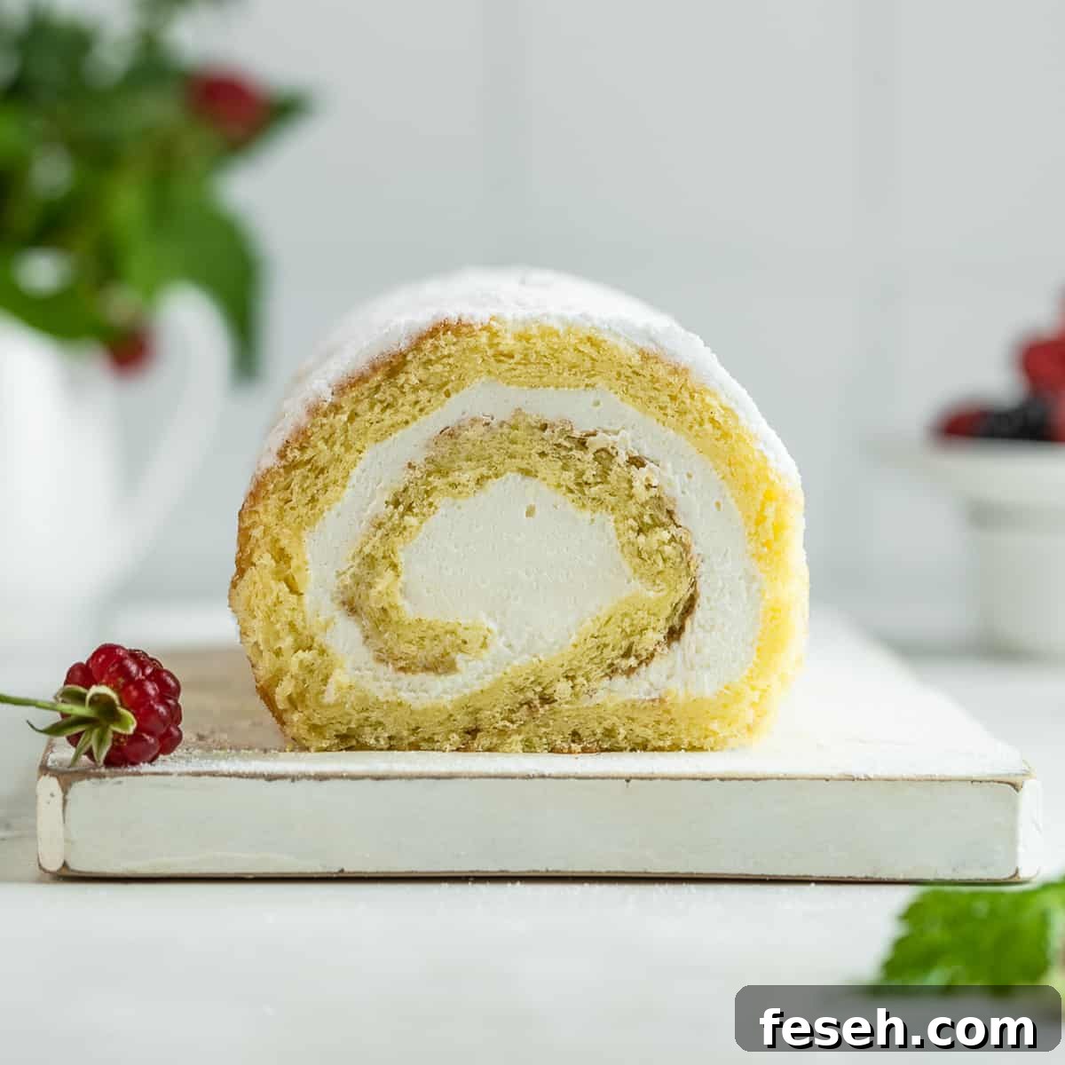 Vanilla sponge cake roll on a serving board.