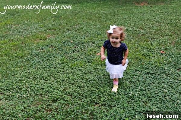 A young girl walking in a grass field.