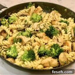 A pan full of cooked chicken & broccoli pasta