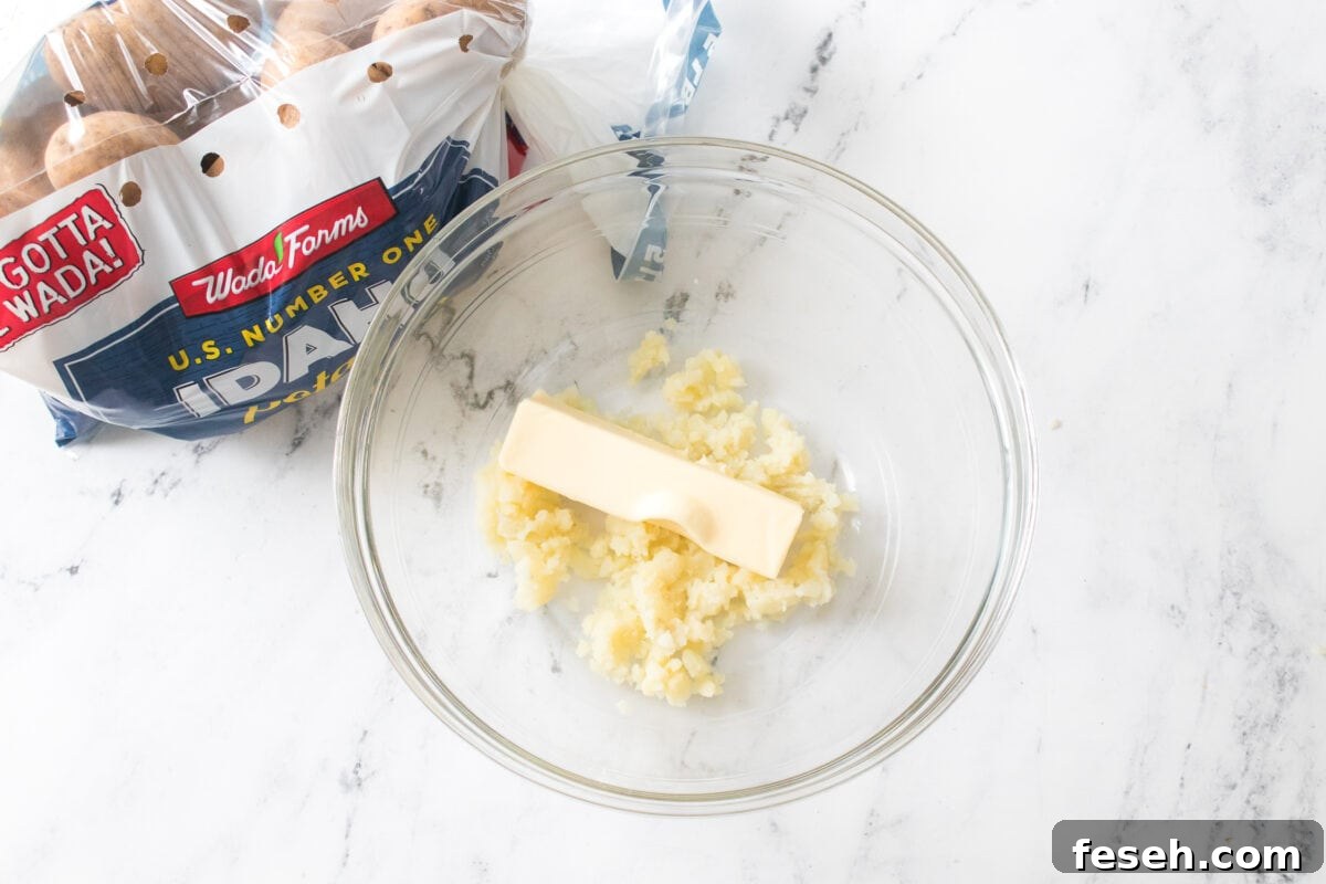 glass bowl with mashed potatoes and butter stick
