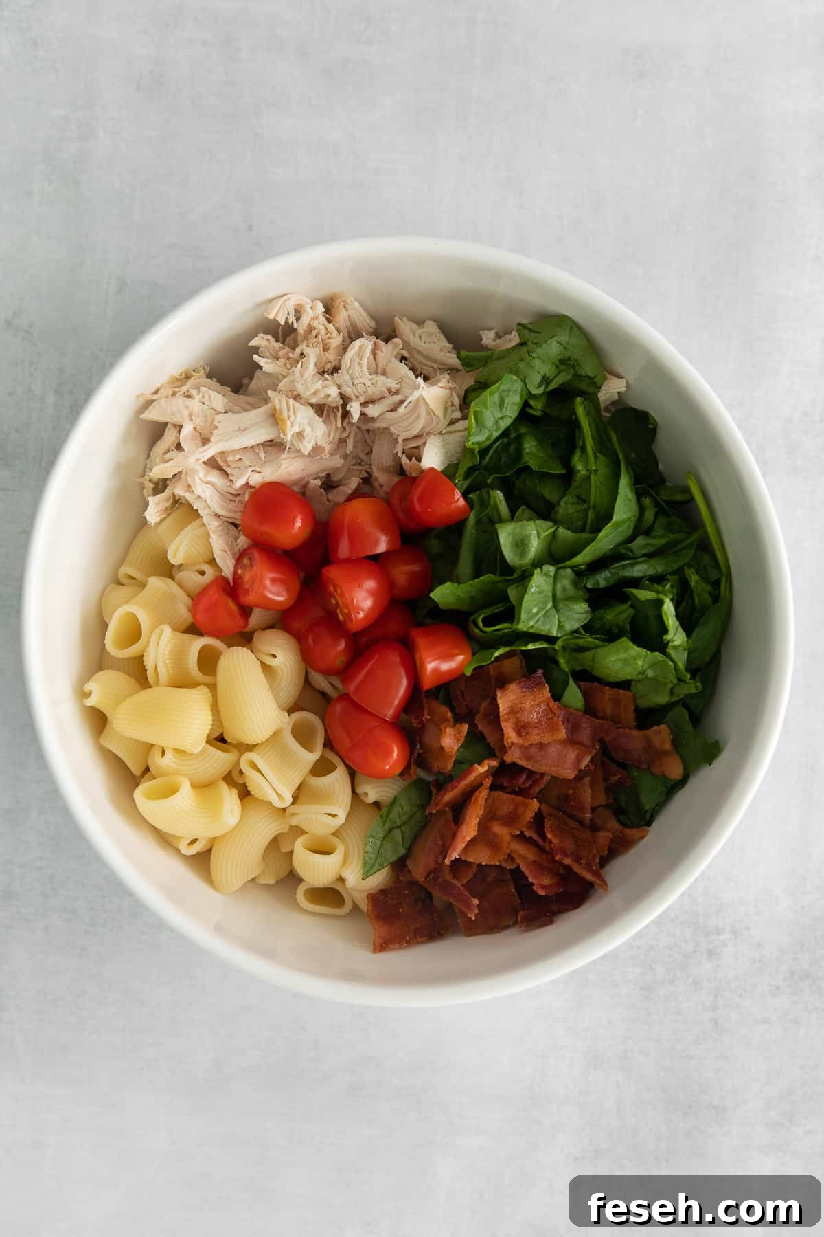 Ingredients for gorgonzola chicken pasta salad in a bowl.